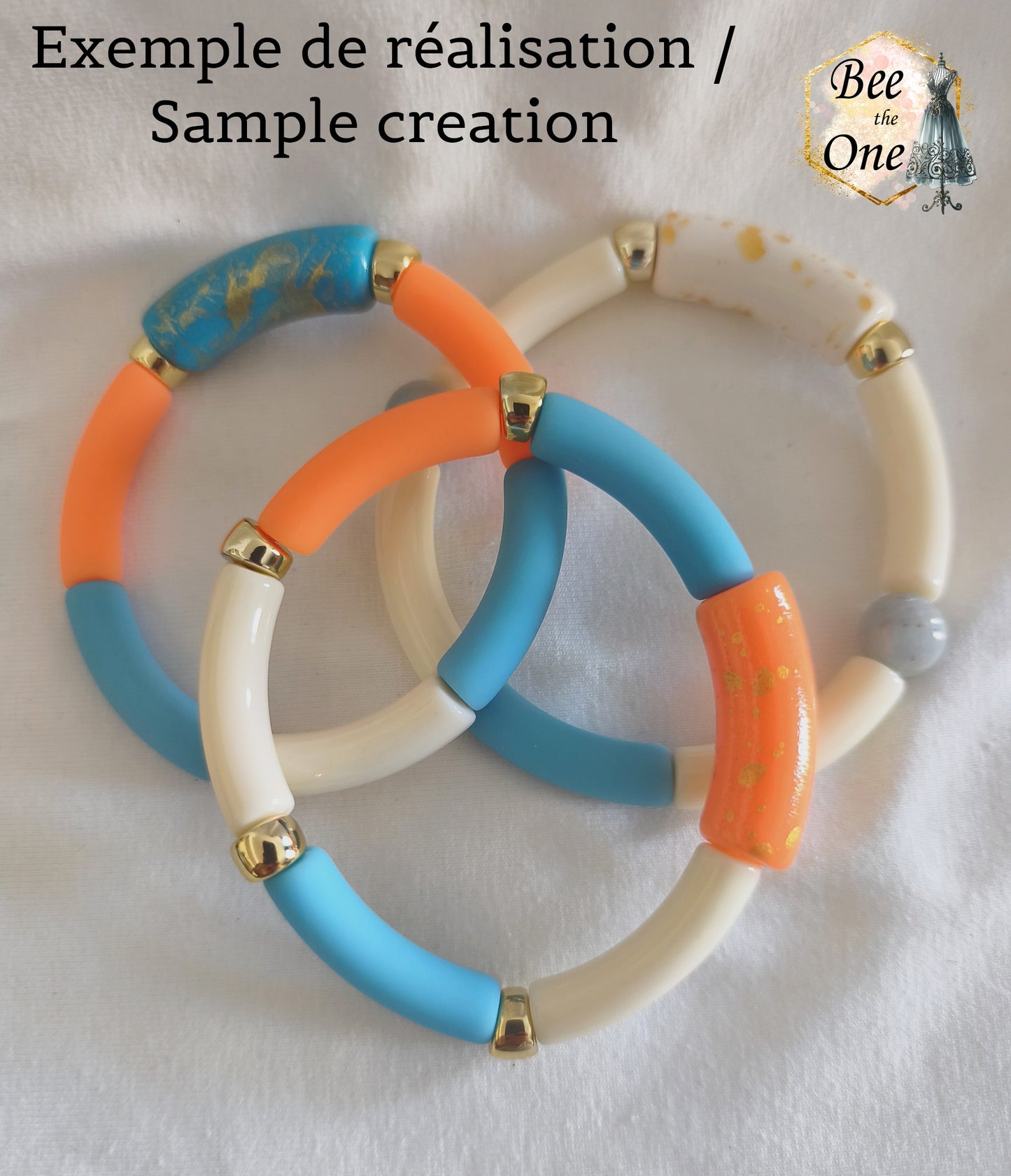 Bracelets réalisés avec de grandes perles tubes incurvées en acrylique mesurant 34x11 mm. Les autres perles sont plus fines ou sont des intercalaires dorés. Bracelets disposés sur un fond blanc.