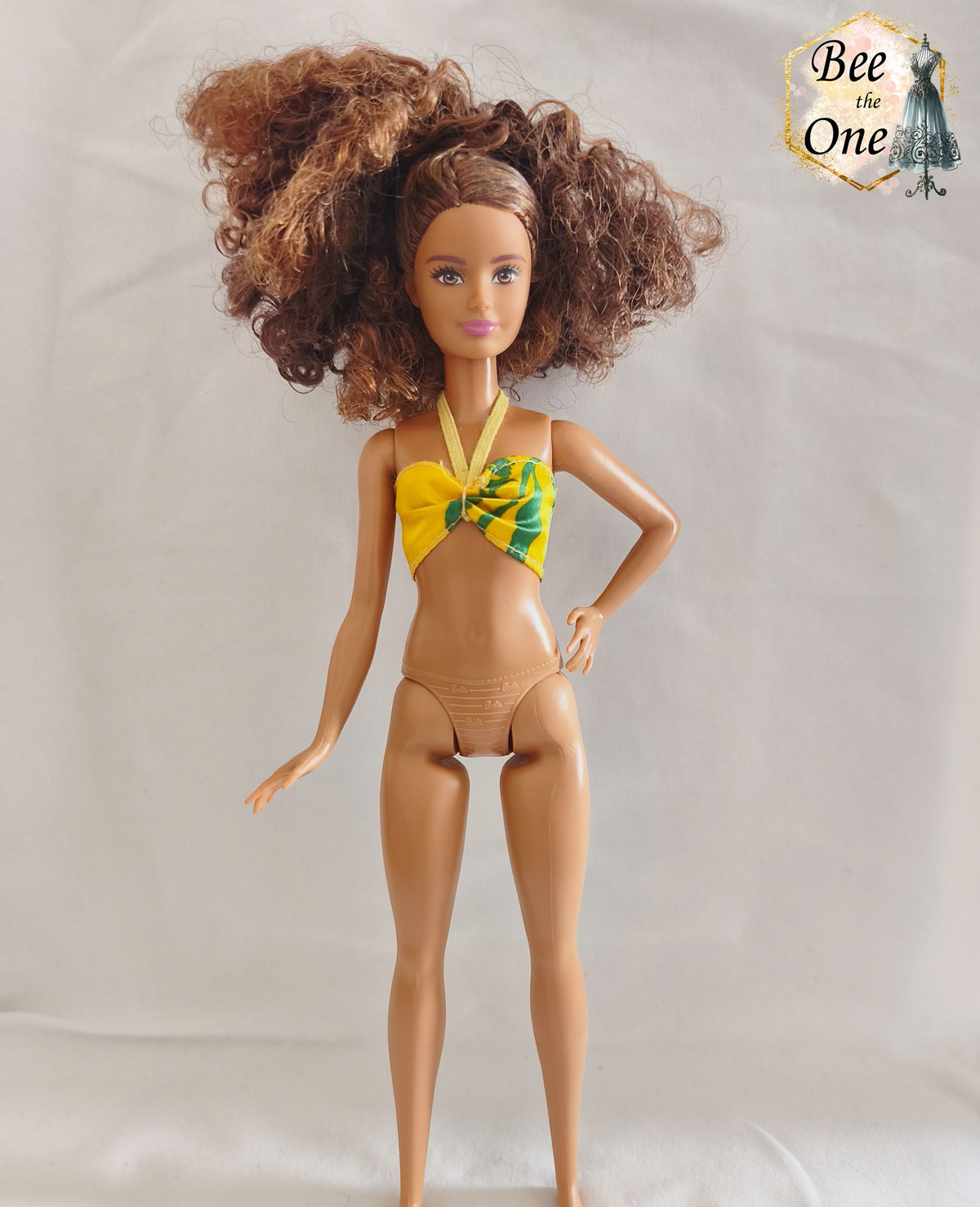 Haut de maillot brassière vintage jaune à motifs verts et lien tour de cou, issu de la poupée Ariel Sea Fashion Tyco 1992, présenté sur mannequin poupée sur fond blanc.