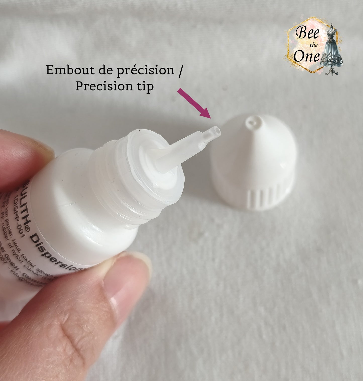 Flacon applicateur de colle Hasulith Dispersion de 10 ml avec bouchon blanc, sur un fond blanc texturé. Gros plan embout