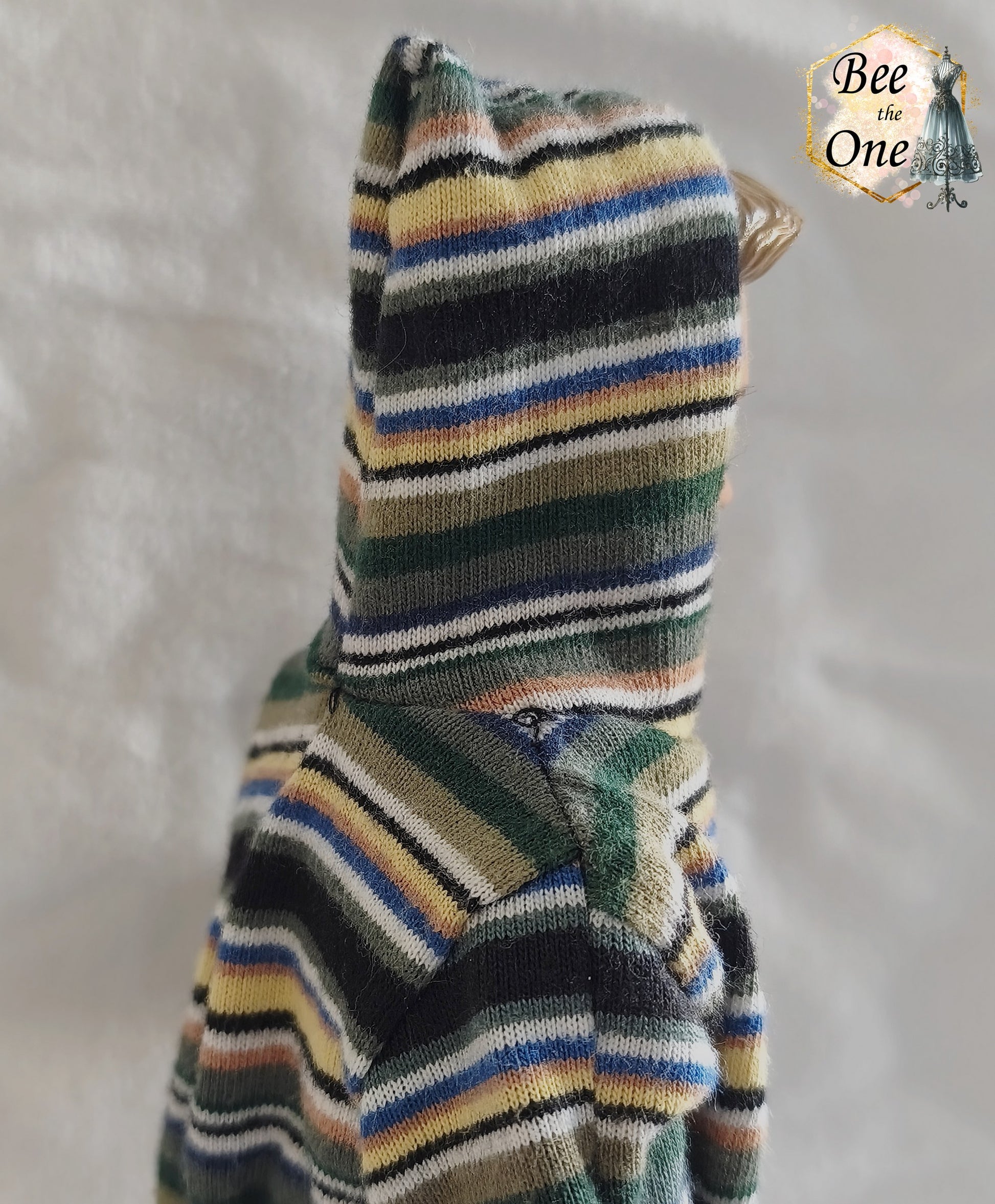 T-shirt à capuche à manches courtes et rayures multicolores (vert, bleu, jaune, blanc) pour poupée Ken Shaving Fun 1994, porté par une poupée blonde sur fond blanc. Vue de côté