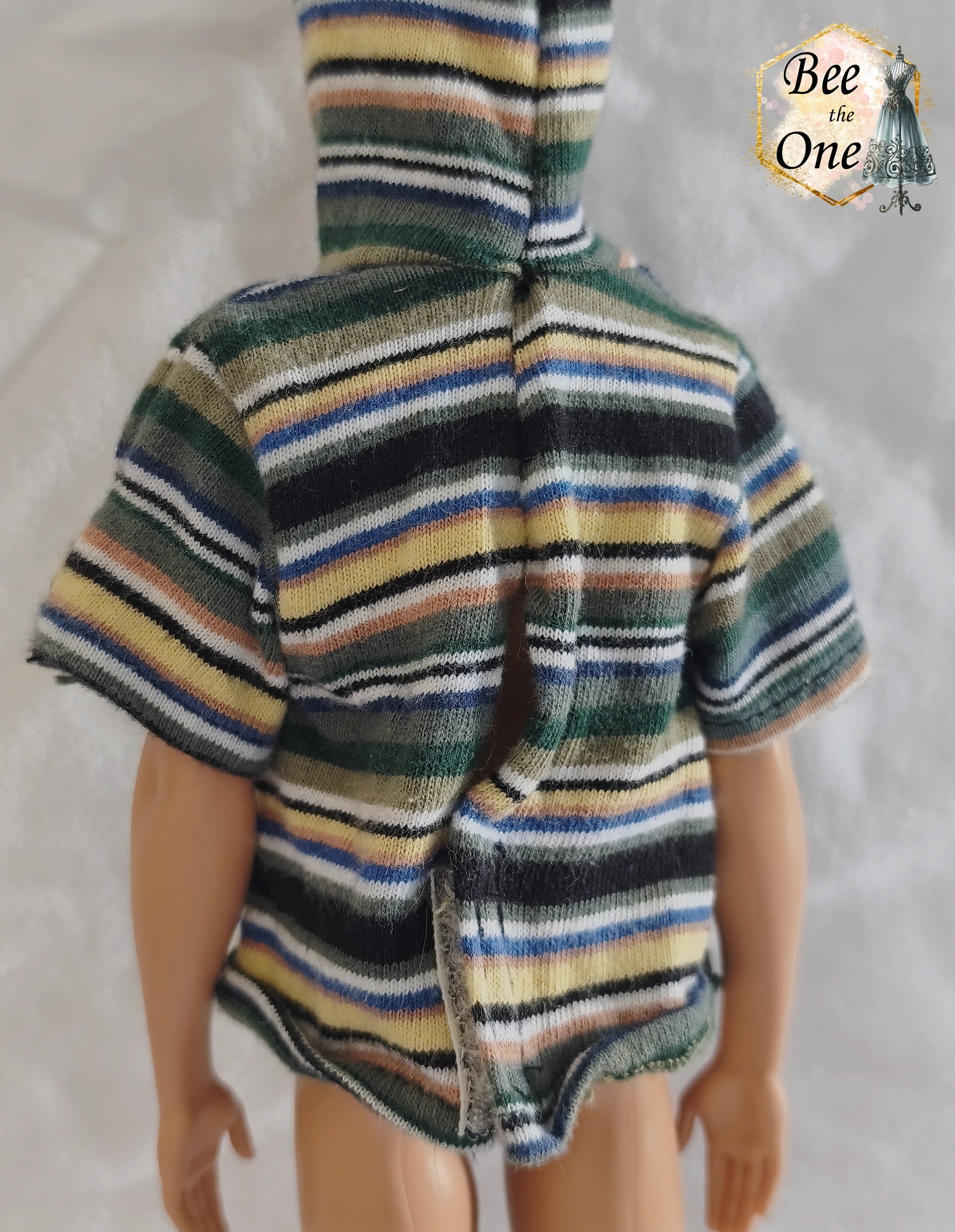 T-shirt à capuche à manches courtes et rayures multicolores (vert, bleu, jaune, blanc) pour poupée Ken Shaving Fun 1994, porté par une poupée blonde sur fond blanc. Vue de dos
