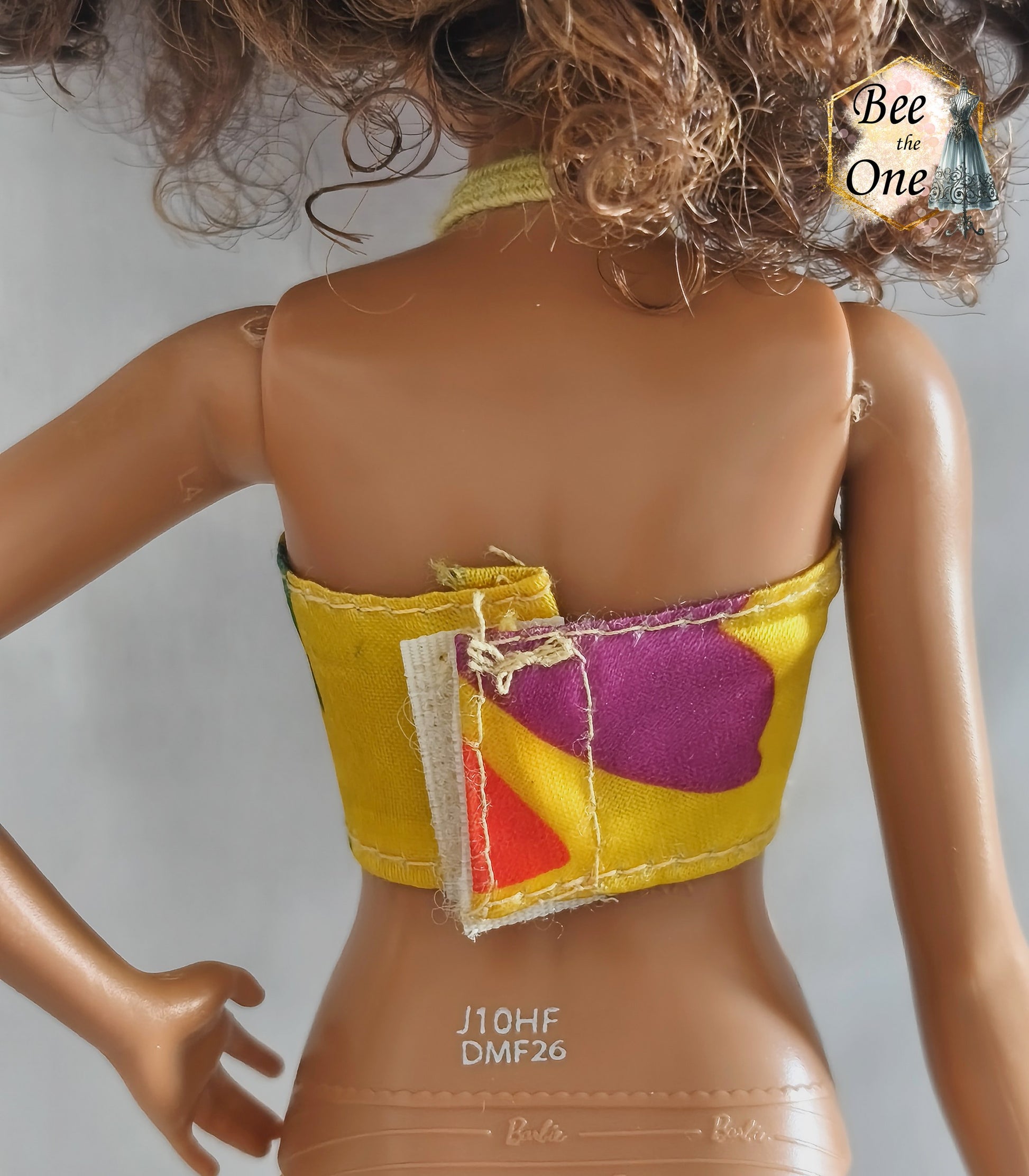 Haut de maillot brassière vintage jaune à motifs verts et lien tour de cou, issu de la poupée Ariel Sea Fashion Tyco 1992, présenté sur mannequin poupée sur fond blanc. Gros plan dos