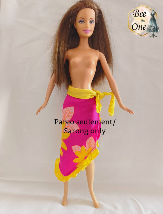 Paréo sarong de plage rose fuchsia à motifs de fleurs tropicales jaunes et orange avec bordure et ceinture nouée jaune fluo, vêtement d'origine pour poupée Barbie Tropical Holiday, porté par une poupée brune sur fond blanc