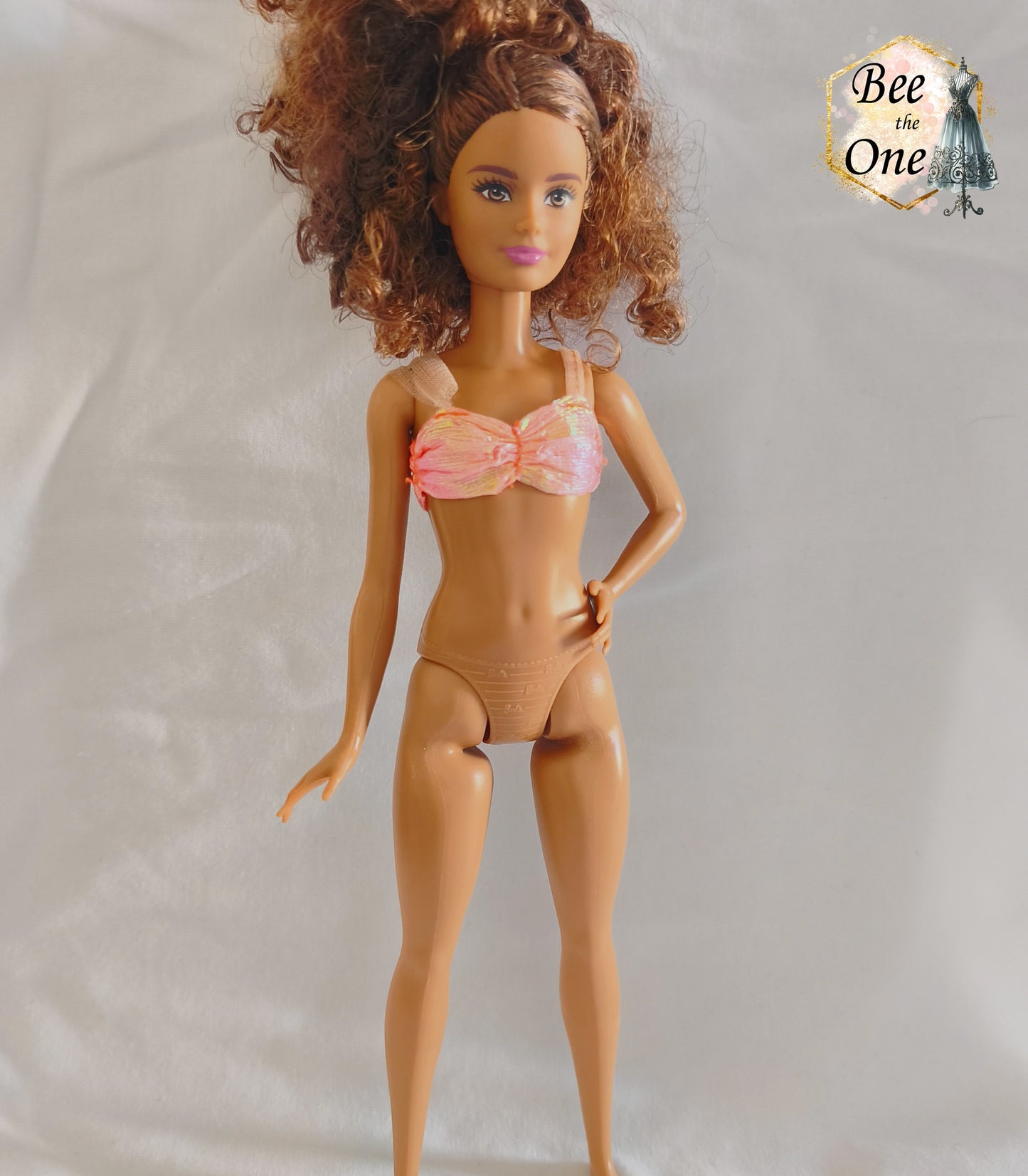 Brassière de bikini bustier rose pailleté et irisé pour poupée Skipper Mermaid & Sea Twins 1993, portée par une poupée brune sur fond blanc.