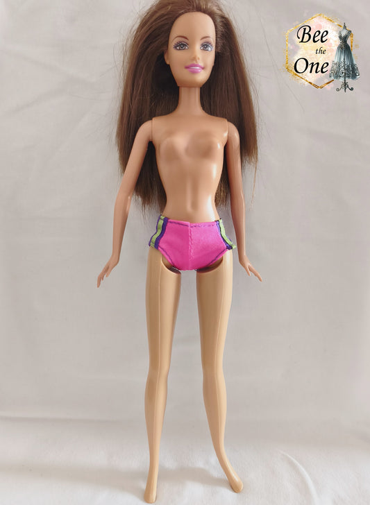 Culotte de maillot de bain rose fuchsia avec rayures latérales vert fluo et violettes, vêtement d'origine pour poupée Barbie Surf City 2000, portée par une poupée brune sur fond blanc.