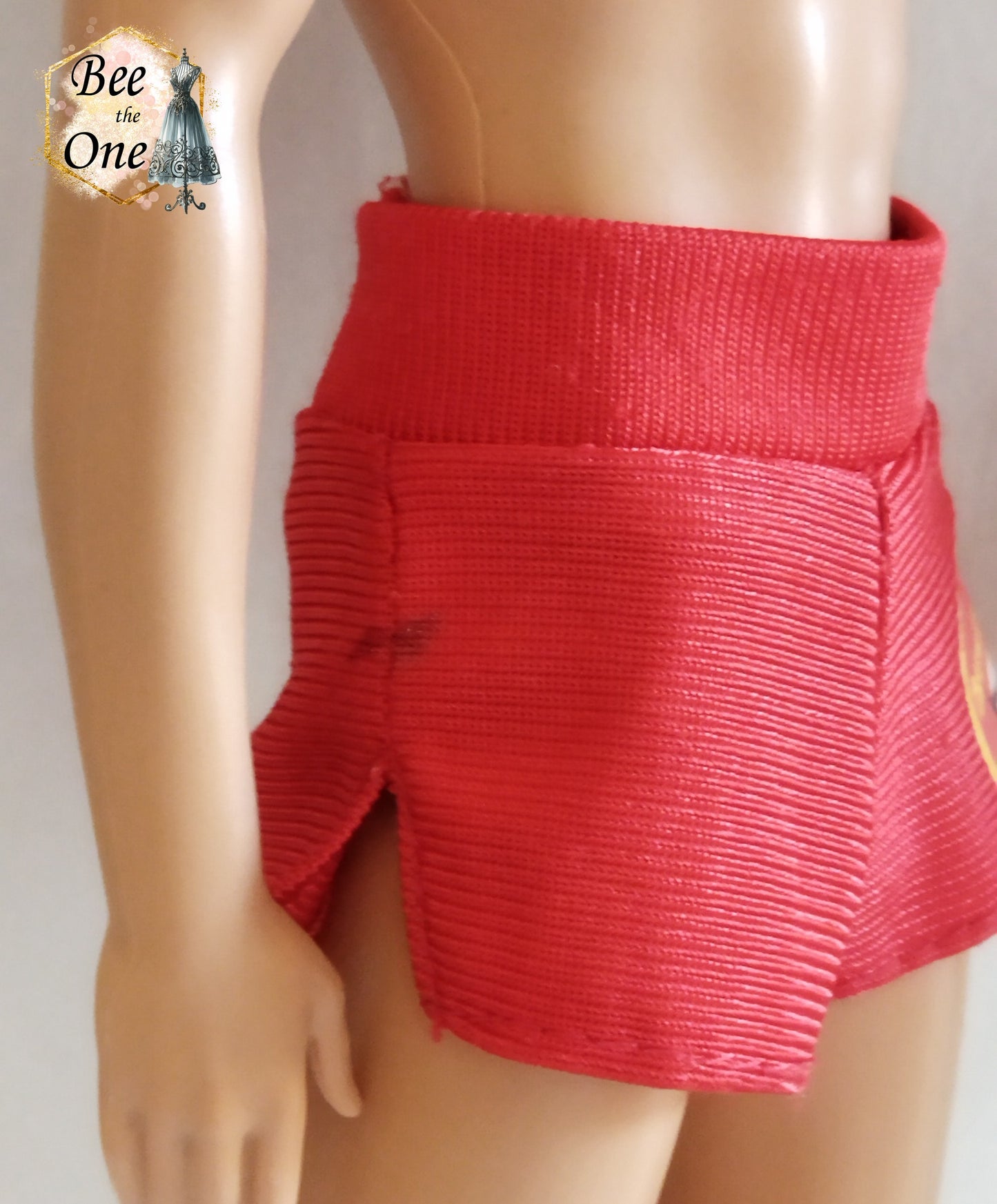 Short de plage pour poupée Ken, rouge avec un patch Baywatch sur le côté. vue côté gauche