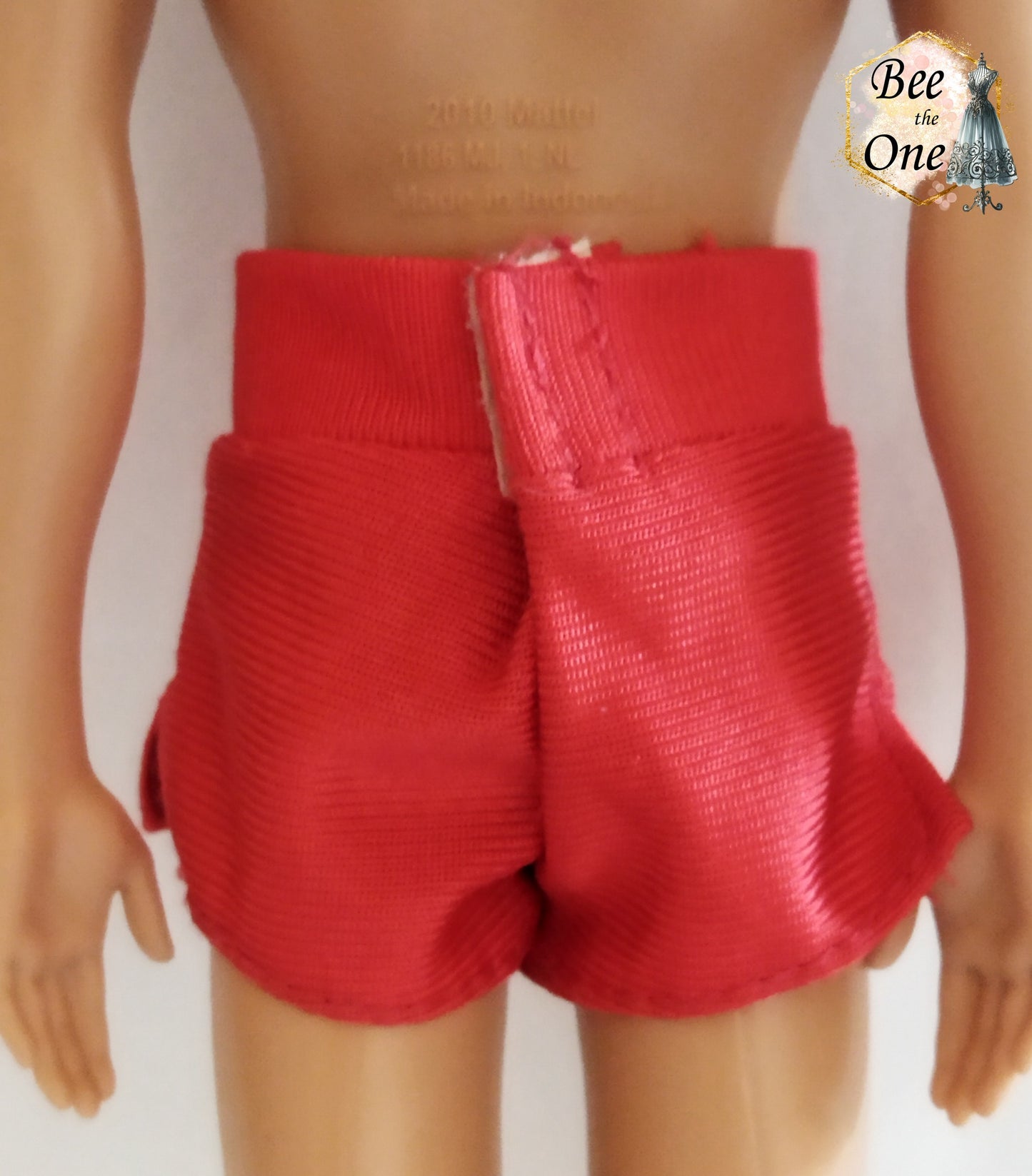Short de plage pour poupée Ken, rouge avec un patch Baywatch sur le côté. Vue de dos