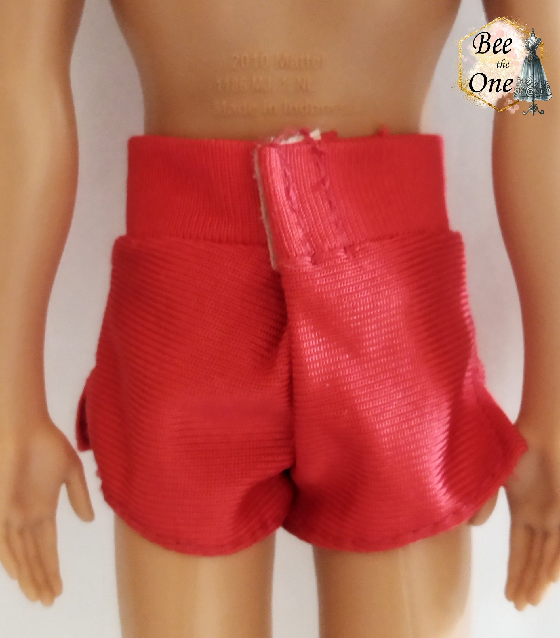 Short de plage pour poupée Ken, rouge avec un patch Baywatch sur le côté. Vue de dos