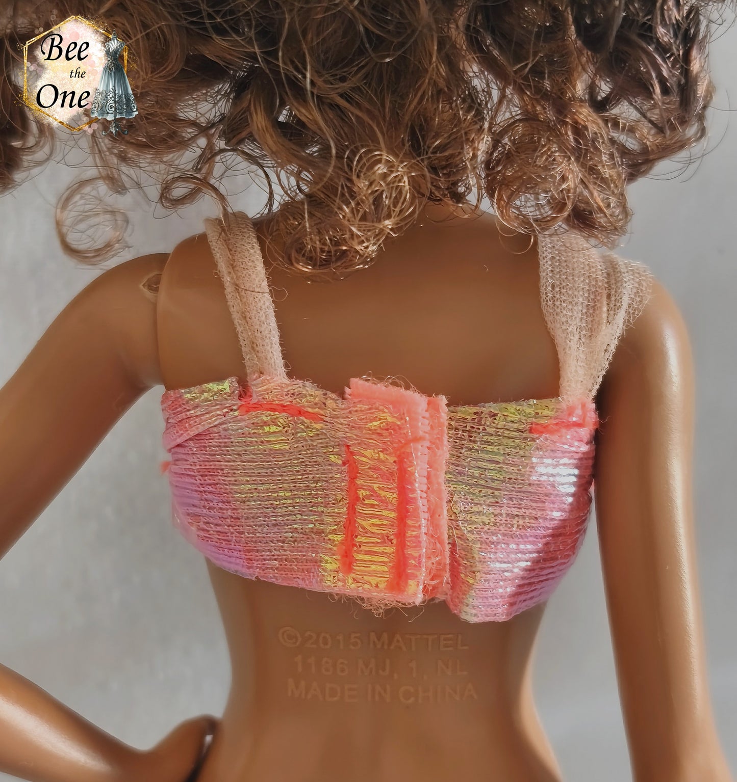 Brassière de bikini bustier rose pailleté et irisé pour poupée Skipper Mermaid & Sea Twins 1993, portée par une poupée brune sur fond blanc. Vue de dos