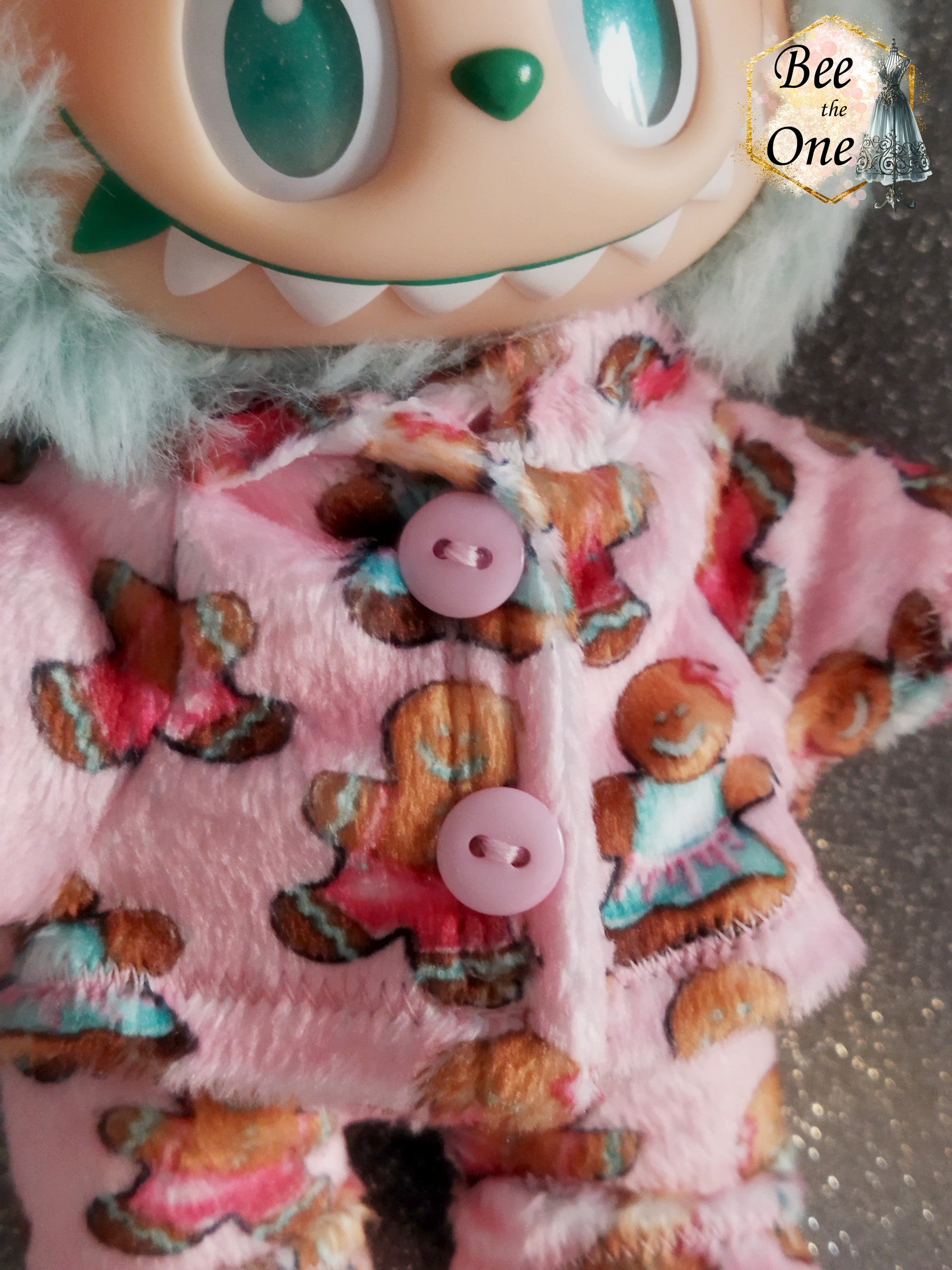 Pyjama hiver pour peluche 20 cm en minky rose à motif de bonhommes en pain d'épice, décoré de deux gros boutons roses sur le devant. Gros plan devant