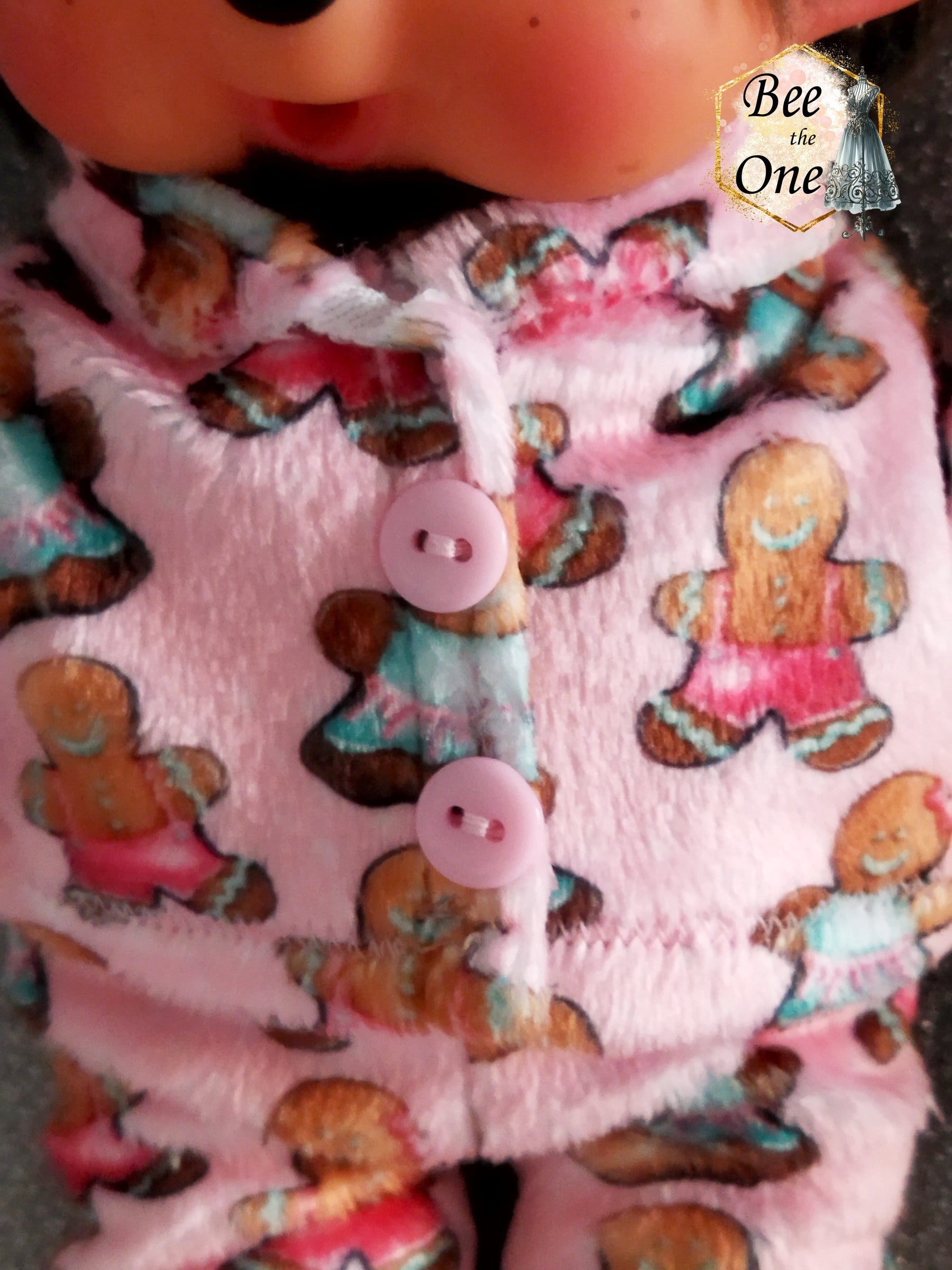 Pyjama hiver pour peluche 20 cm en minky rose à motif de bonhommes en pain d'épice, décoré de deux gros boutons roses sur le devant. Gros plan bouton