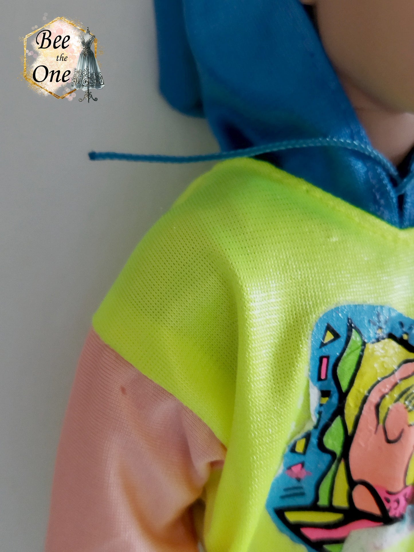 Pull pour poupée Ken en tissu mesh coloré, idéal pour une tenue décontractée ou sportive. Vue manche droite