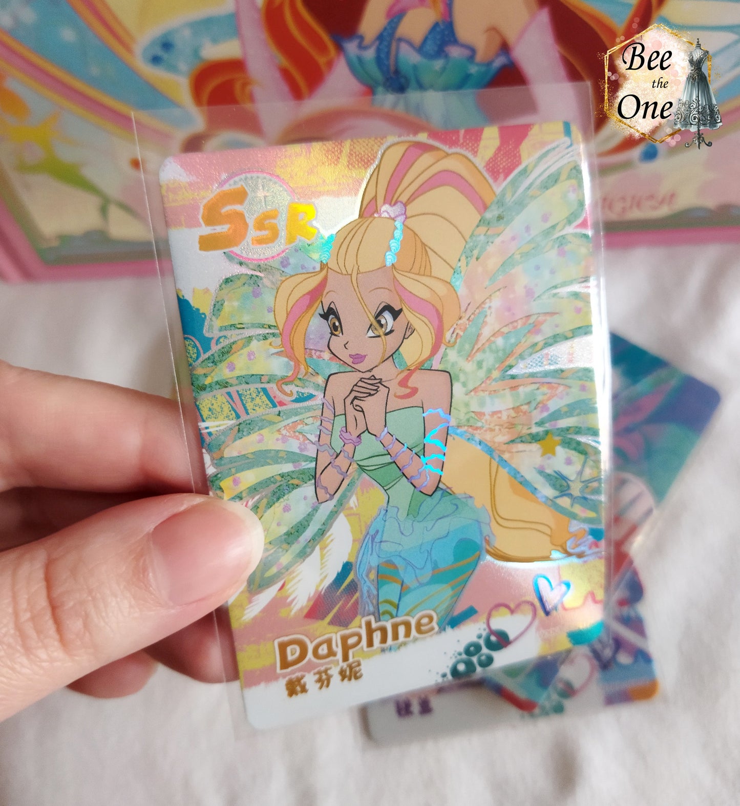 Cartes illustrées inspirées de Winx Club. Gros plan de la carte de Daphne Sirenix, avec des détails captivants et un design dynamique.