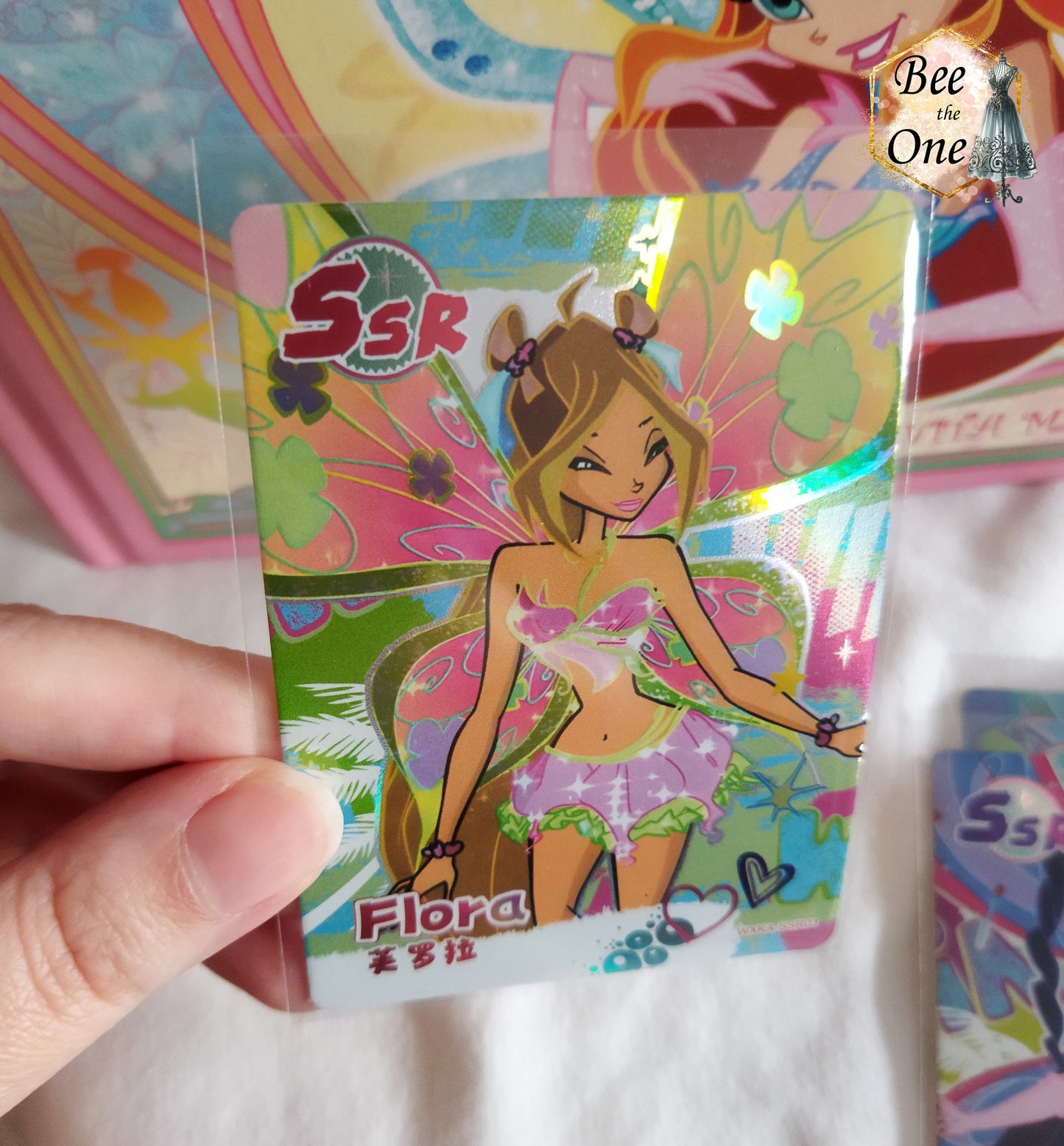Cartes illustrées inspirées de Winx Club. Gros plan de la carte de Flora Believix, avec des détails captivants et un design dynamique.