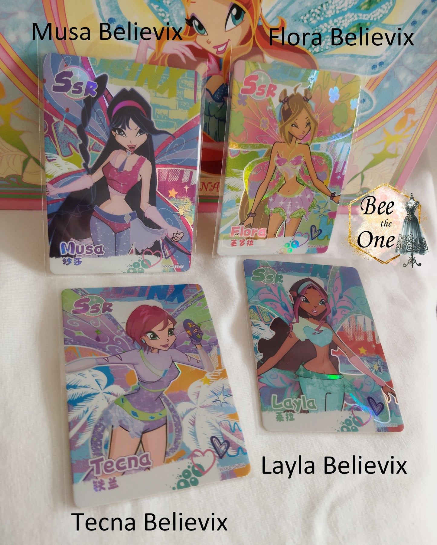 Cartes illustrées inspirées de Winx Club. Chaque carte met en scène un personnage (Musa, Flora, Tecna, Layla), dans sa transformation de fée Believix, avec des détails captivants et un design dynamique.