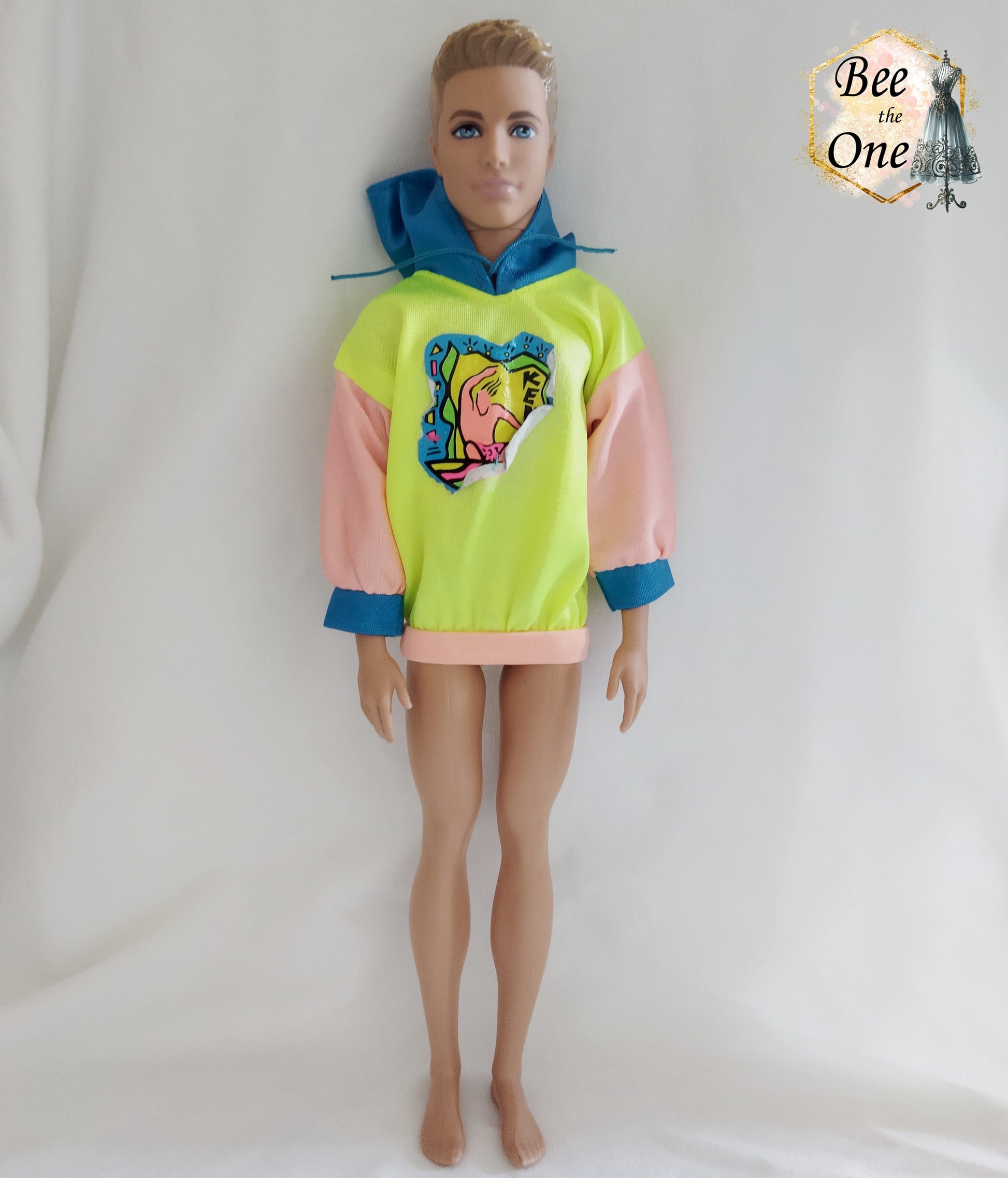 Pull pour poupée Ken en tissu mesh coloré, idéal pour une tenue décontractée ou sportive. Vue porté sur poupée