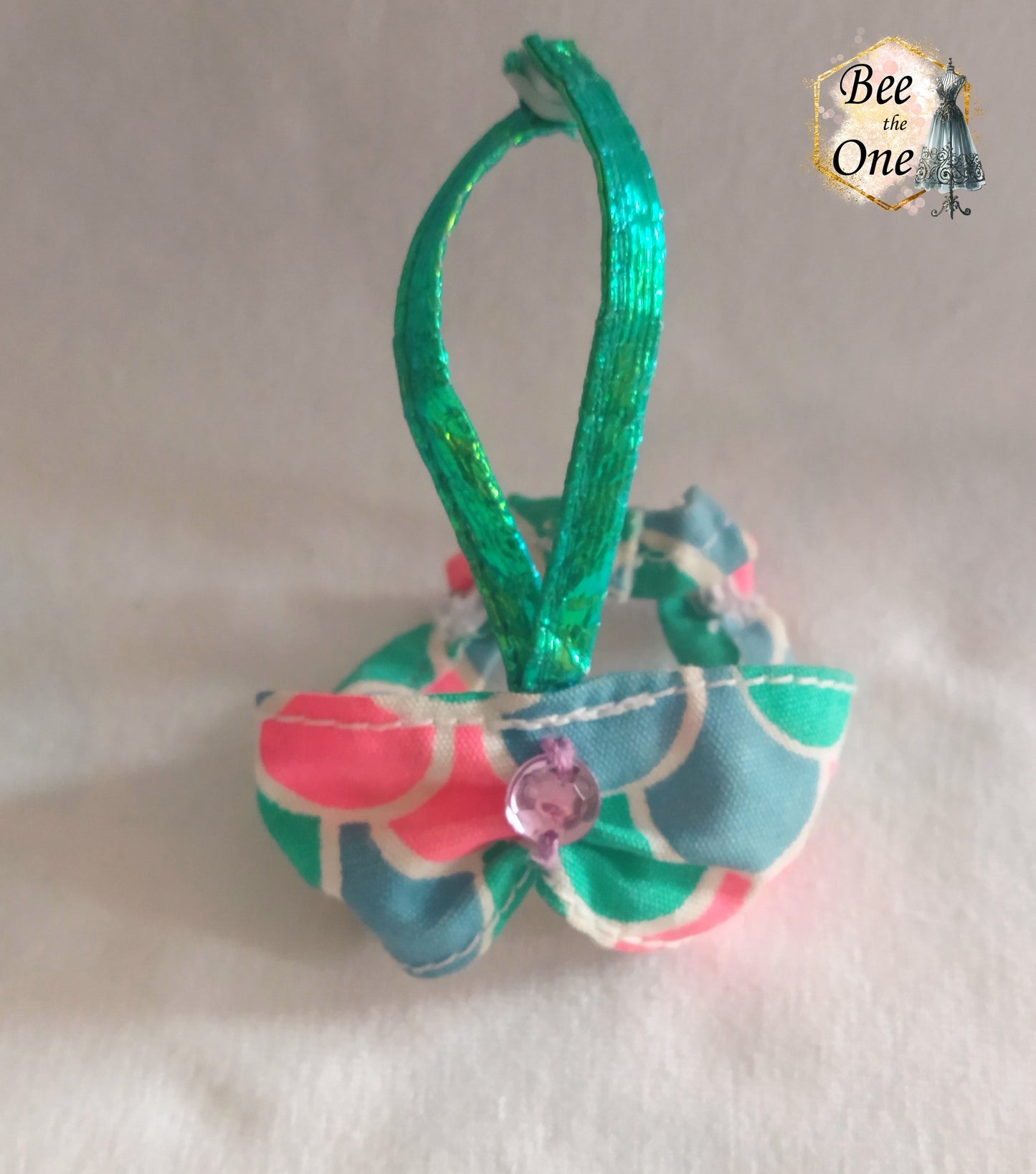 Brassière poupée motif écailles sirène pastel avec ruban vert en gros plan devant