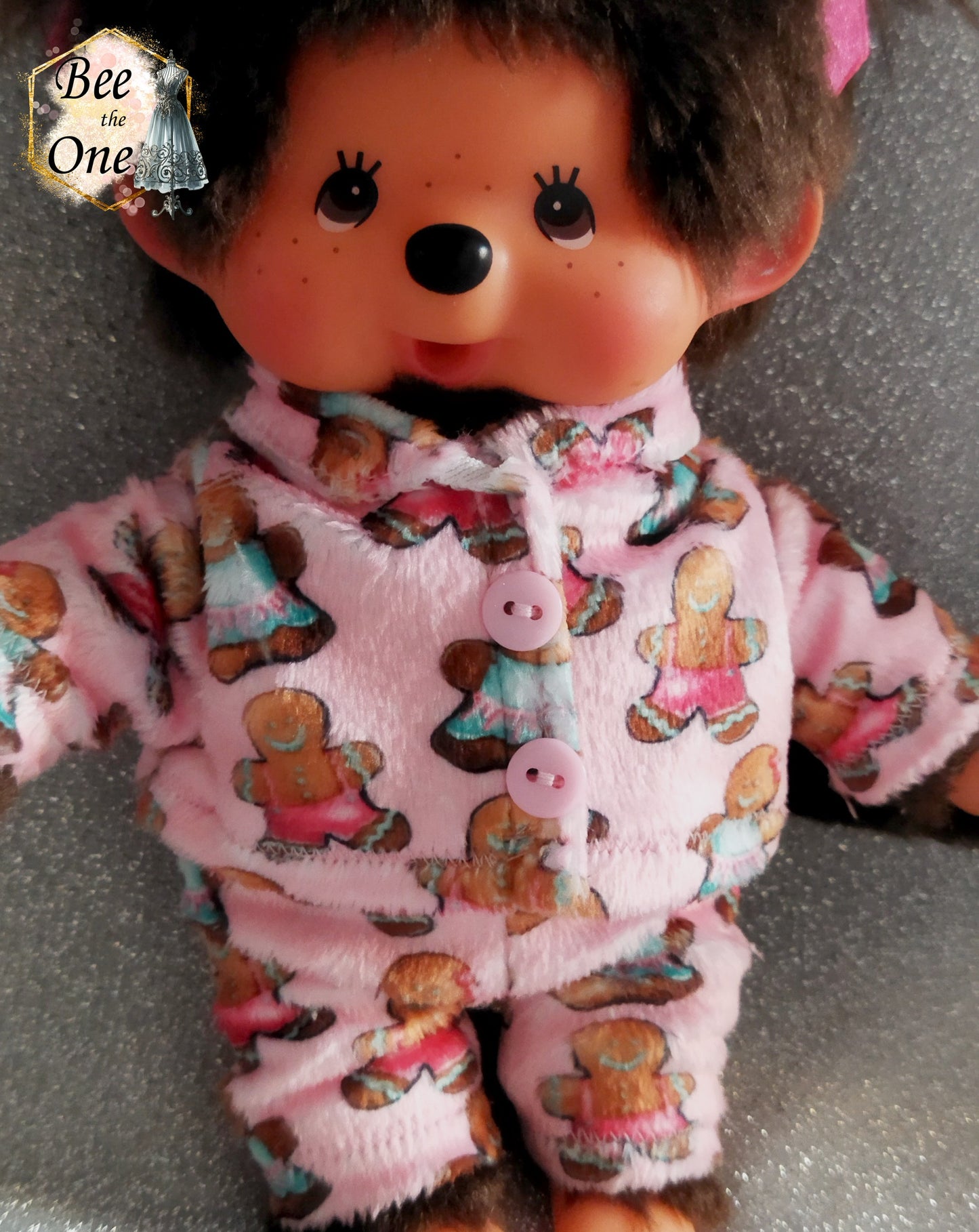 Pyjama hiver pour peluche 20 cm en minky rose à motif de bonhommes en pain d'épice, décoré de deux gros boutons roses sur le devant. Vue devant
