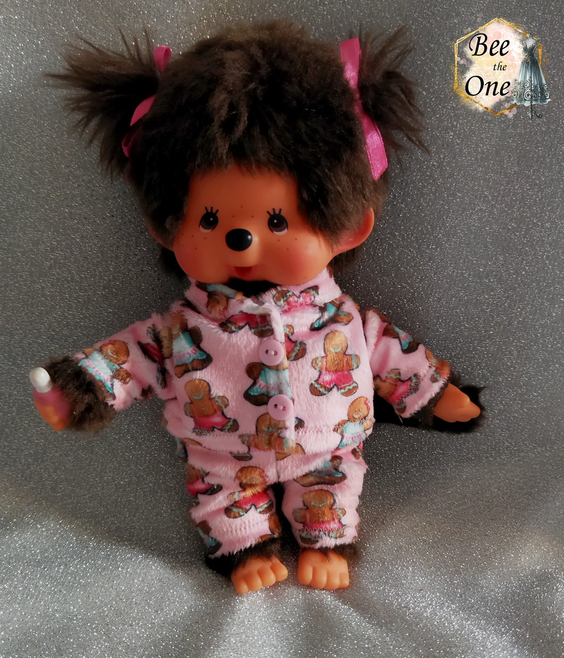 Pyjama hiver pour peluche 20 cm en minky rose à motif de bonhommes en pain d'épice, décoré de deux gros boutons roses sur le devant, porté par Moncchichi